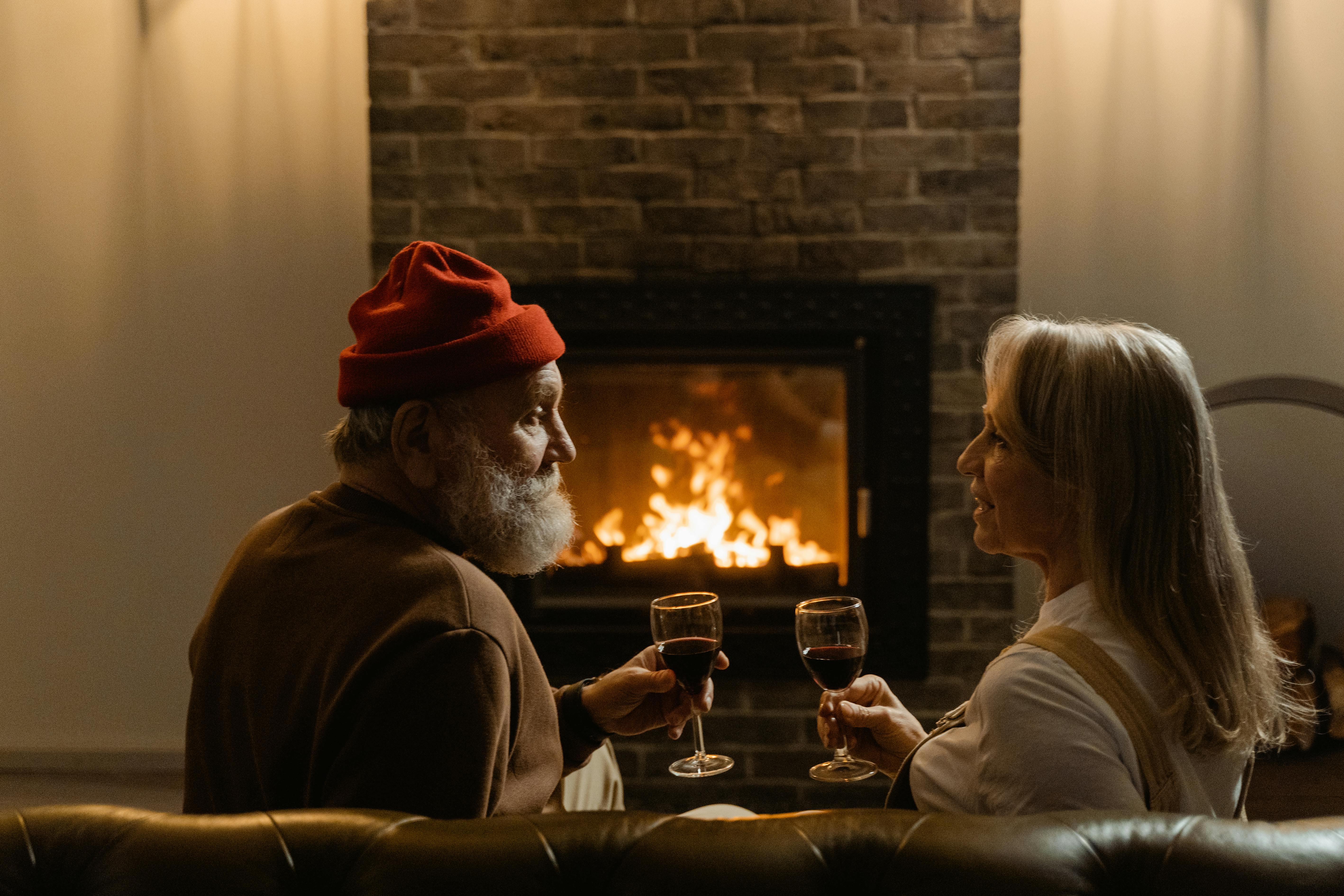 a couple having drinks by the fireplace