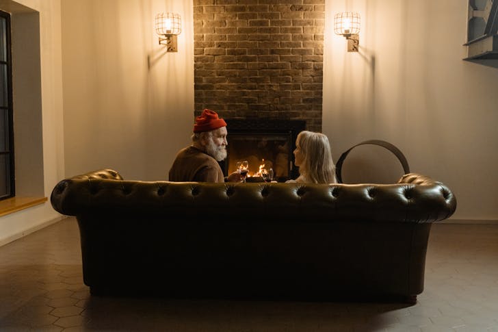 People Sitting on a Couch In Front of a Fireplace