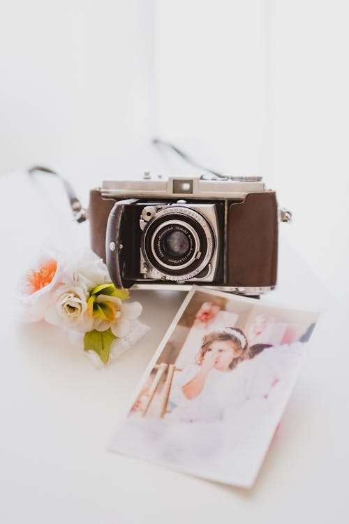 Free Vintage Camera with Photos on White Background Stock Photo