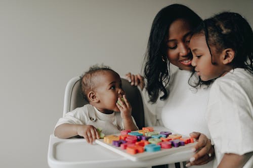 Free Mother with Her Children Looking at a Toy and Smiling  Stock Photo