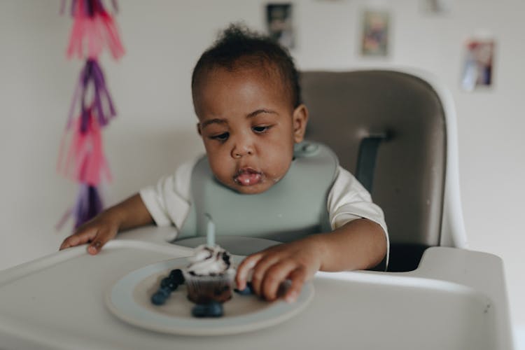 Photograph Of A Baby Eating A Cupcake