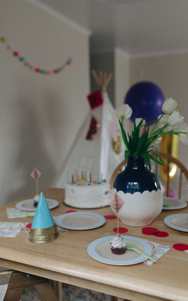 Birthday table with cake, cupcakes and flowers