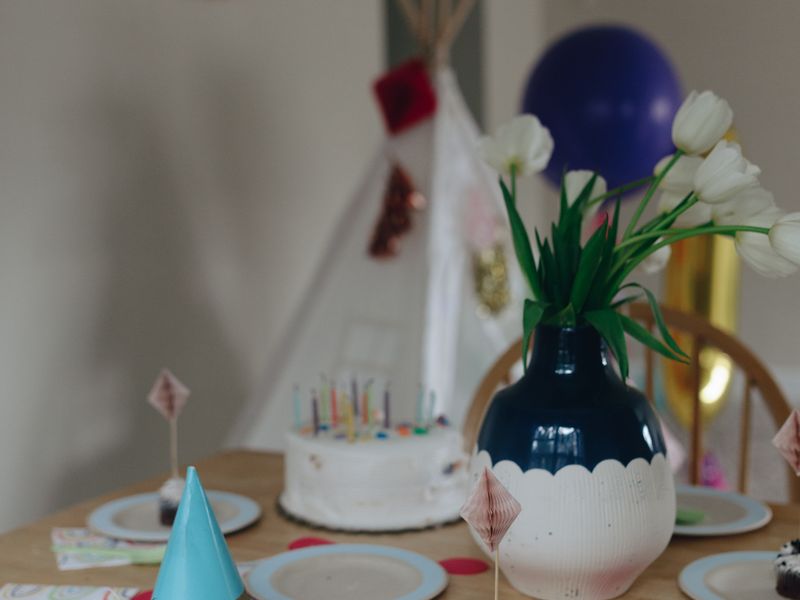 Birthday table with cake, cupcakes and flowers