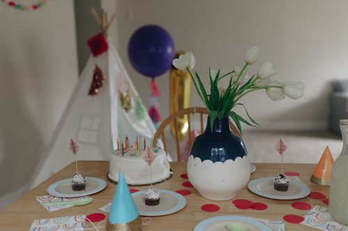 Free Festive indoor birthday setup with cake, cupcakes, flowers, and party decor. Stock Photo