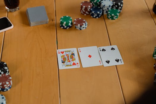 A strategic poker setup with playing cards and colorful chips on a wooden table.