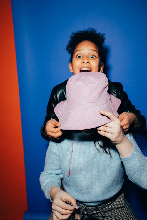 Girl Holding A Bucket Hat on Another Girl's Head