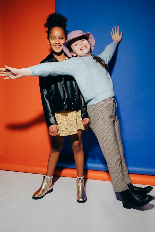 Girl in Blue Sweater Leaning on a Girl Wearing a Black Jacket