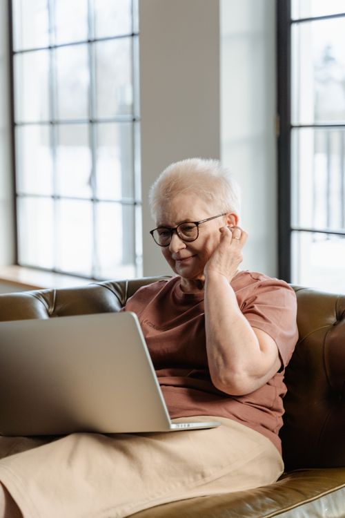 Free Elderly woman engaging with laptop indoors, enjoying online leisure activities. Stock Photo