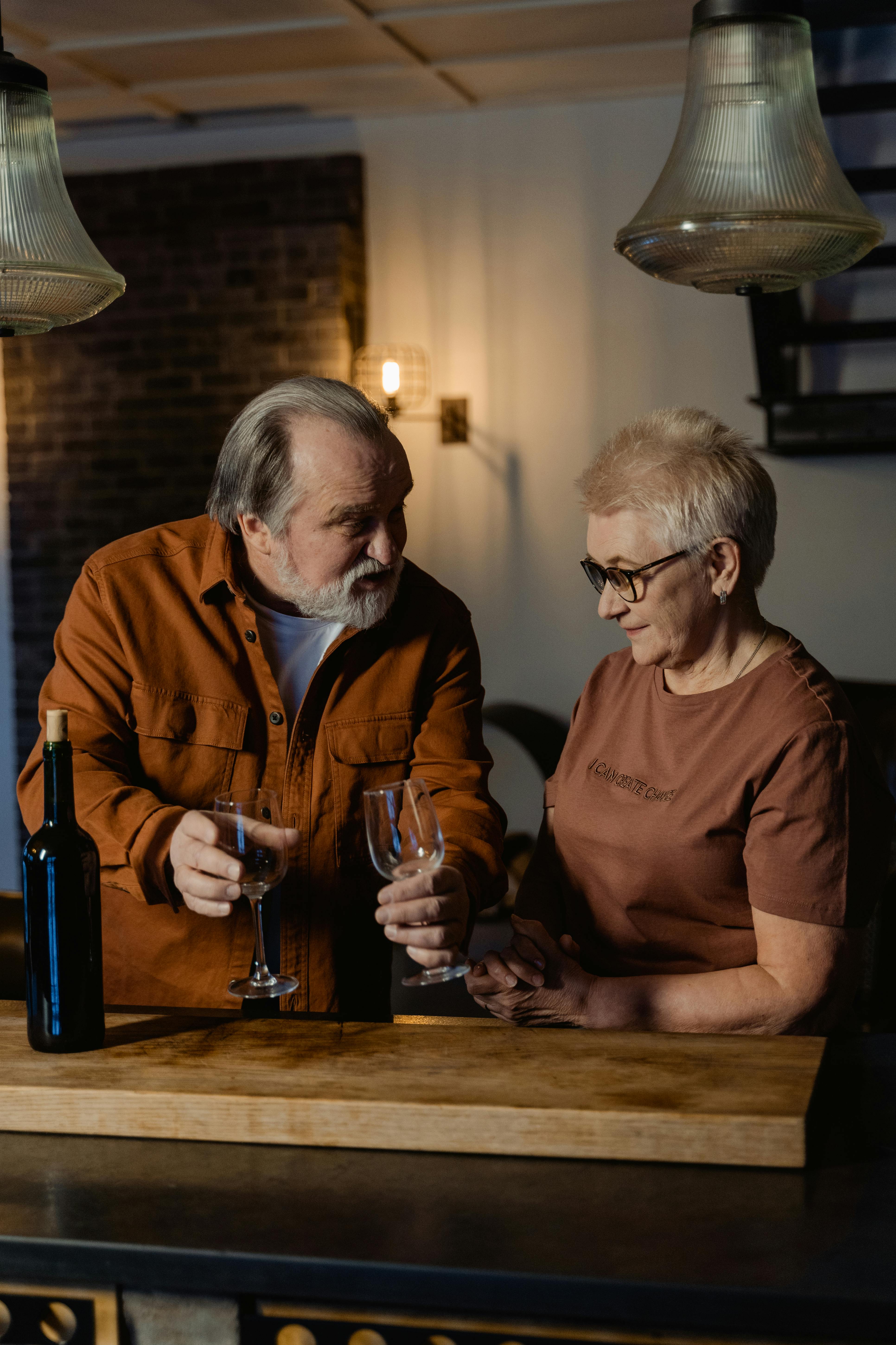 A senior couple spending quality time together indoors with wine.