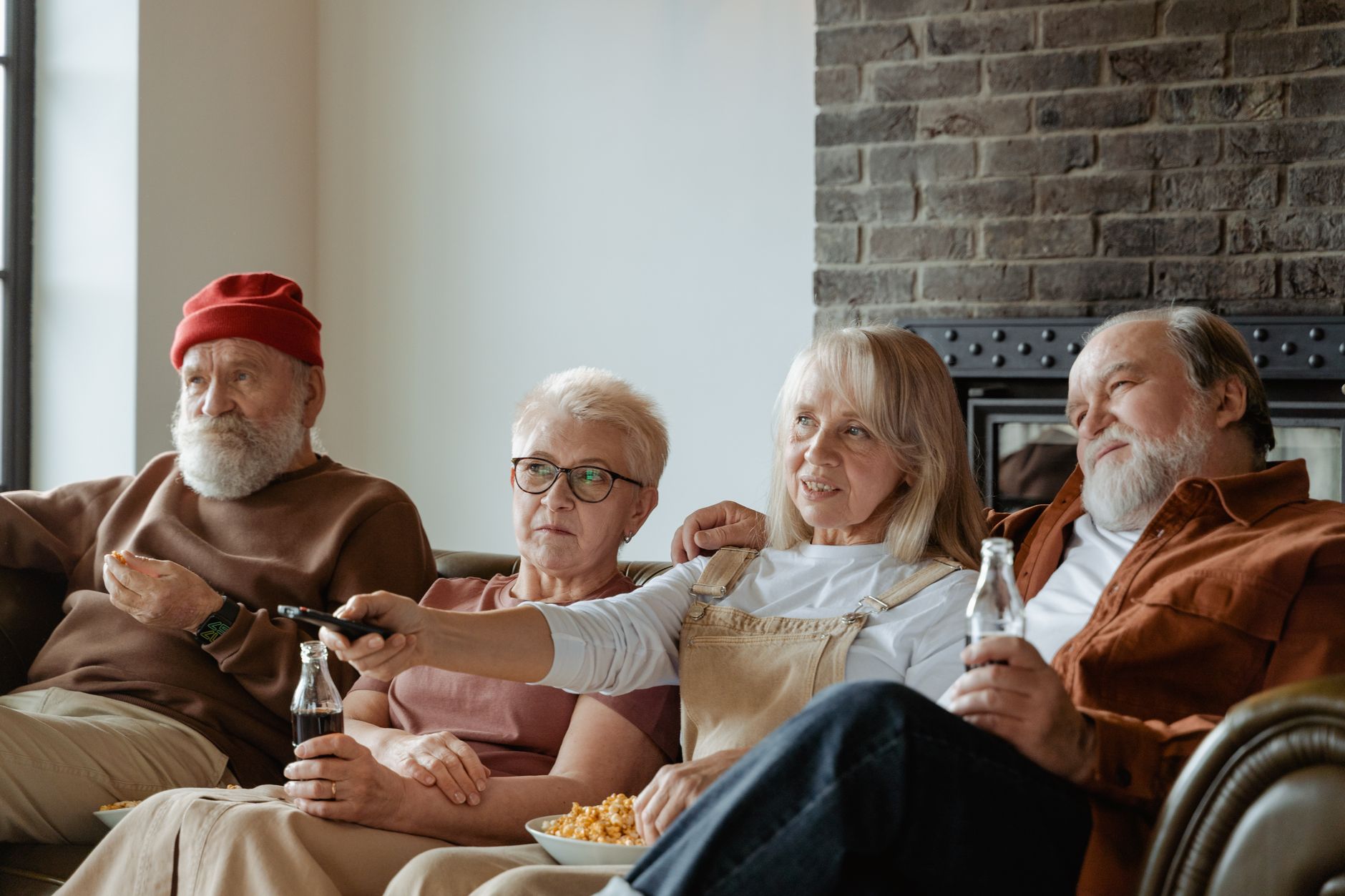 A group of senior adults relaxing and watching TV together in a cozy living room.
