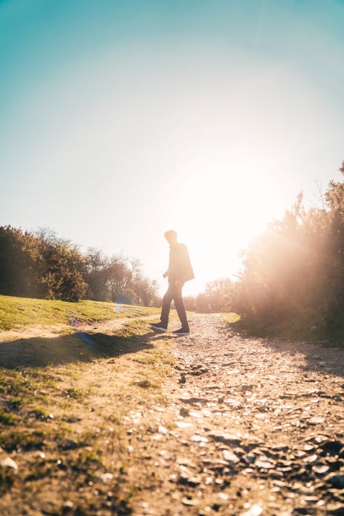 A Person Walking Outdoors on a Sunny Day