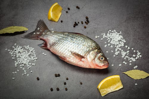 Raw Fish With Ingredients on Black Surface