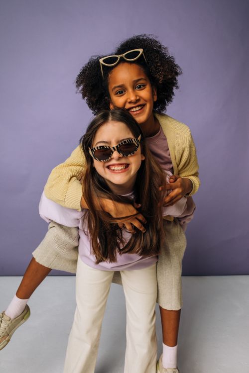 Free Two girls enjoying a playful piggyback ride, laughing and having fun together. Stock Photo