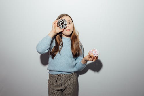 Girl in Blue Sweater Holding Doughnuts