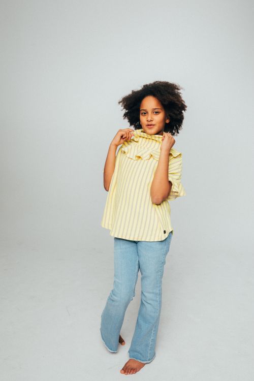 Free A joyful young girl in a stylish outfit with a bright background, expressing happiness. Stock Photo