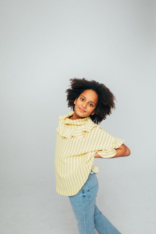 Girl in Yellow and White Striped Shirt and Blue Denim Jeans