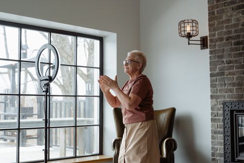 Free Elderly woman enjoying indoor activity, creating content with ring light. Stock Photo