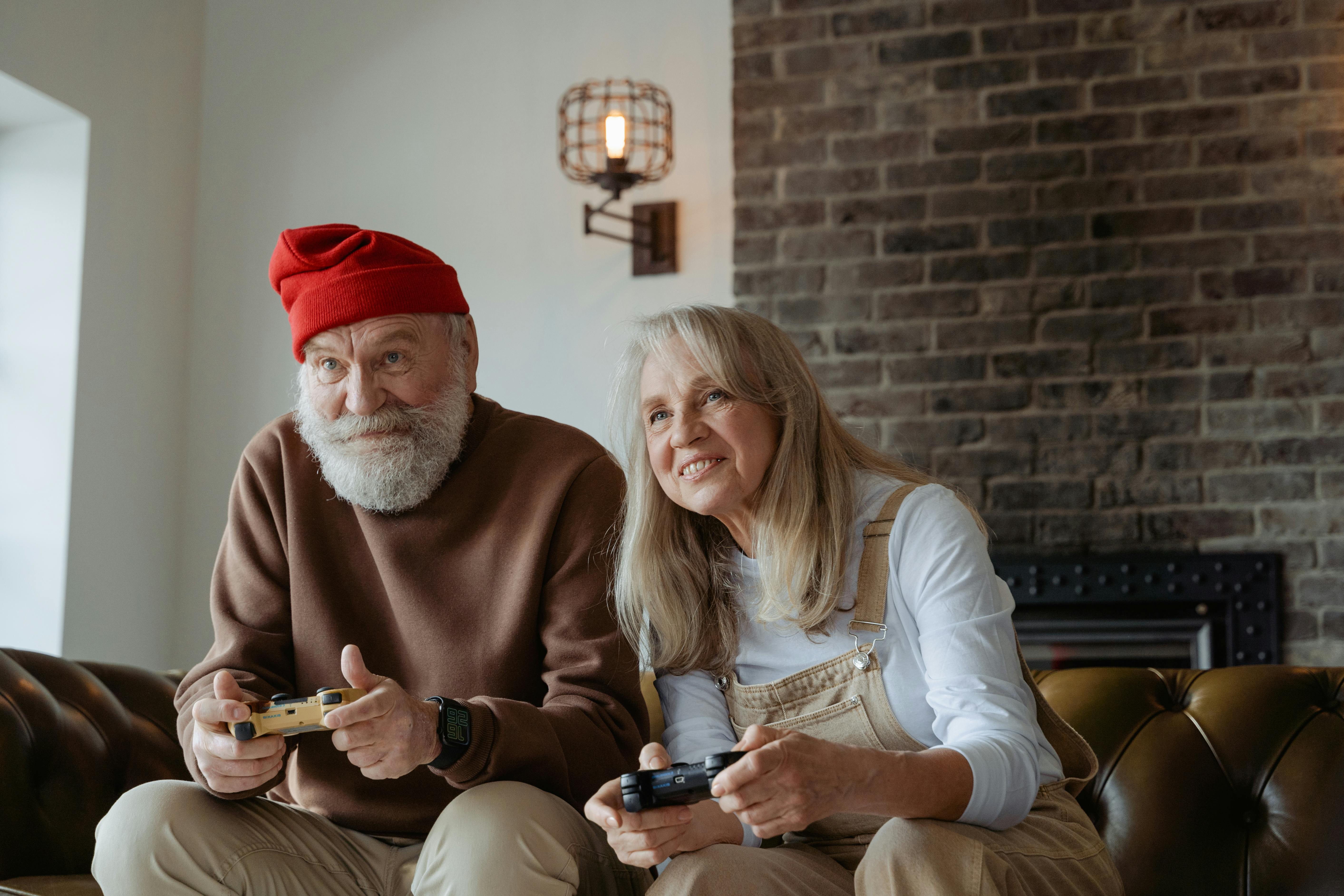 man in red knit cap and woman in white long sleeve shirt sitting on a leather couch