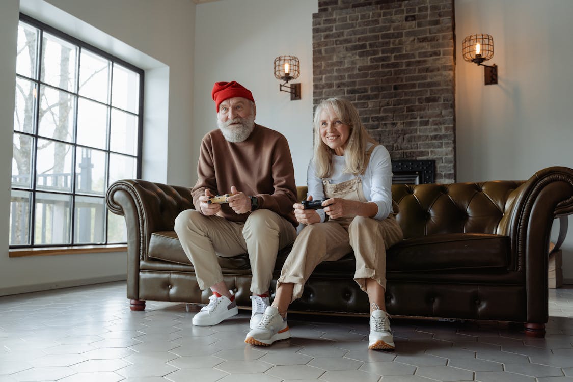 Free Man and Woman Sitting on Brown Leather Couch Stock Photo