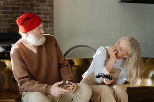 Man Sitting on a Sofa Beside Woman in White Long Sleeve Shirt