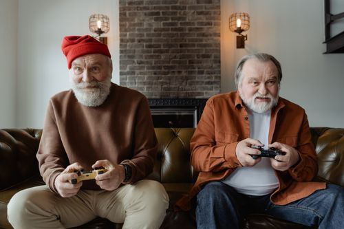 Free Elderly men with gray hair play video games, embracing leisure and hobbies indoors. Stock Photo