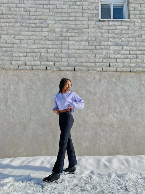 A Woman Posing by a Brick Wall