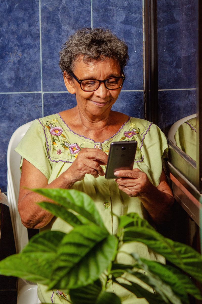 Sa mère, tout sourire, qui vient de recevoir sa recharge