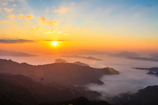 Stunning sunrise scene with mist-covered valleys and majestic mountain landscape.