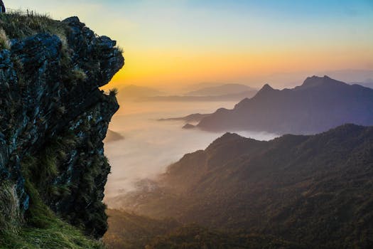 Magnificent sunrise view over misty mountains and lush green valleys, capturing the beauty of nature.