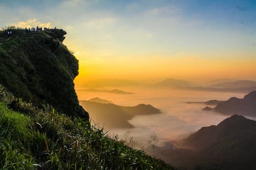 Landscape Photography of Cliff With Sea of Clouds during Golden Hour