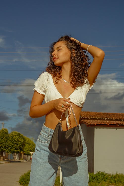 A Pretty Curly-Haired Woman in White Crop Top Posing