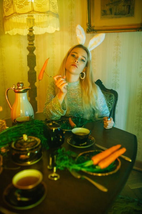 Free A Woman Wearing a Sweater and a Bunny Ear Headband Eating Carrots Stock Photo