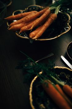 A tasteful arrangement of fresh carrots on a vintage ceramic plate, perfect for culinary and food styling themes.