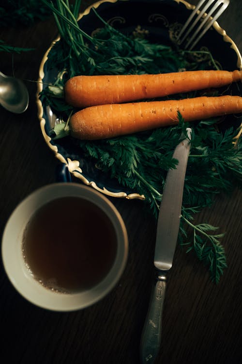 Carrots on Ceramic Plate Beside a Cup of Tea