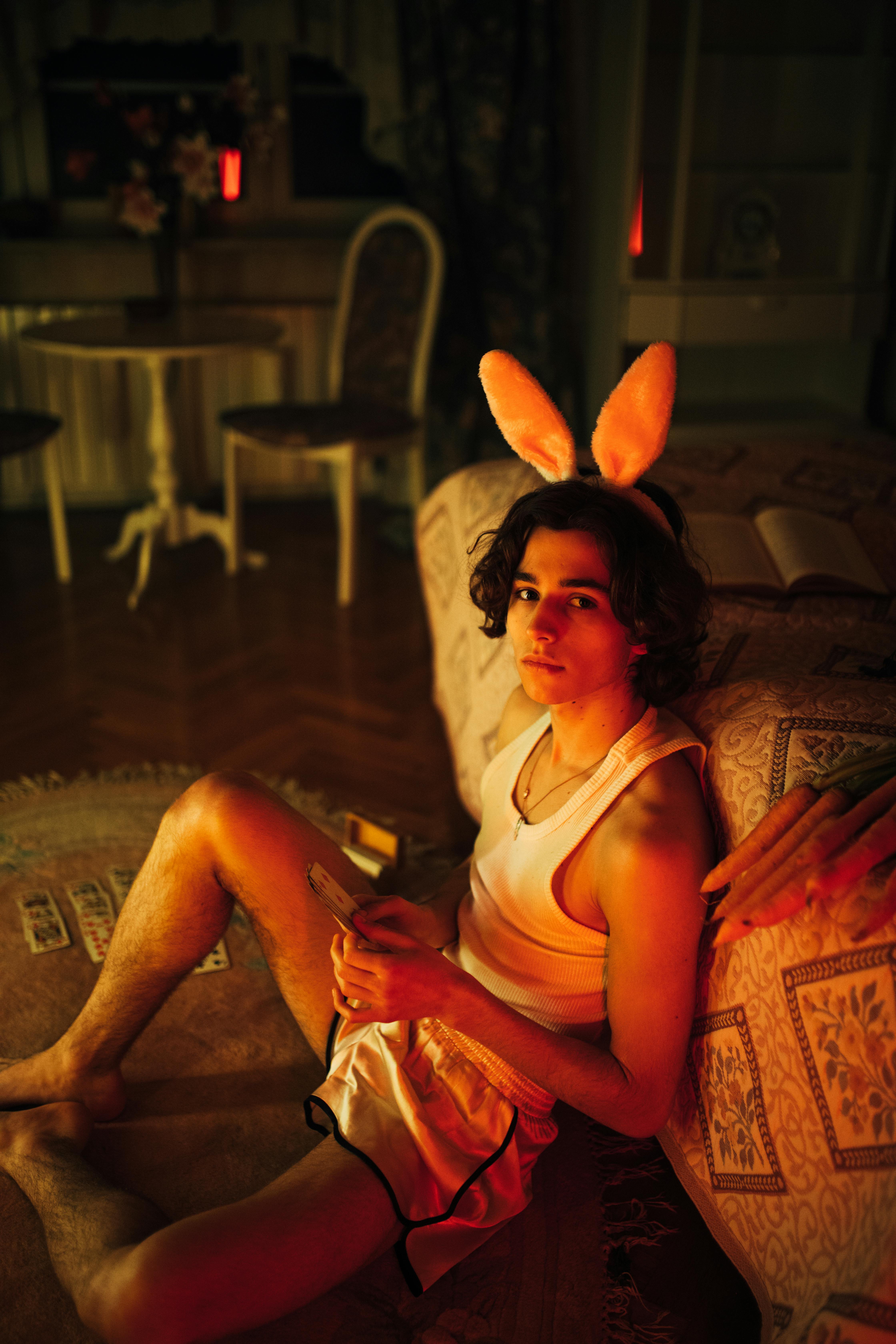 woman in white tank top and orange skirt sitting on brown and beige floral sofa