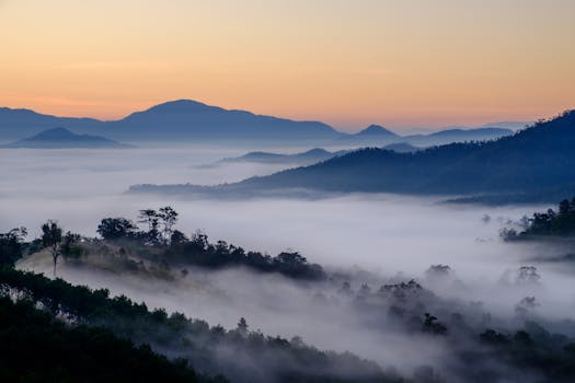 A breathtaking aerial view of Mae Hong Son mountains enveloped in mist during sunrise. Captures serene nature.