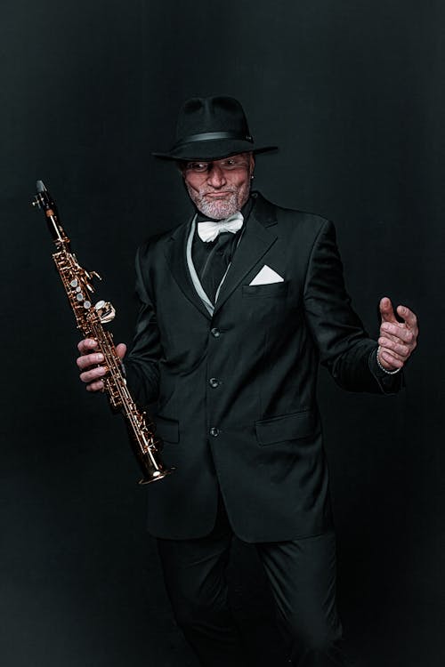 

A Man in a Suit Holding a Saxophone