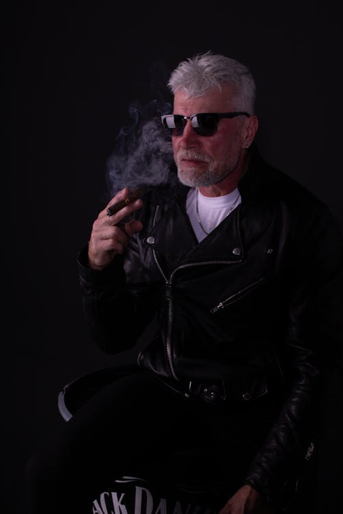 Free An Elderly Man in Black Leather Jacket Smoking Stock Photo