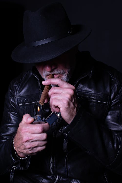 
A Bearded Man Lighting a Cigar