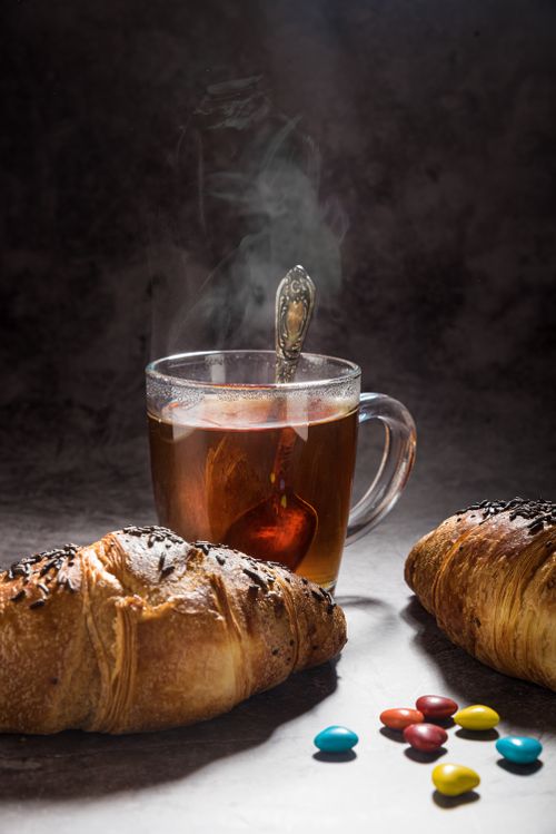Free Warm up to a cozy breakfast featuring hot tea and fresh croissants with sweet treats. Stock Photo