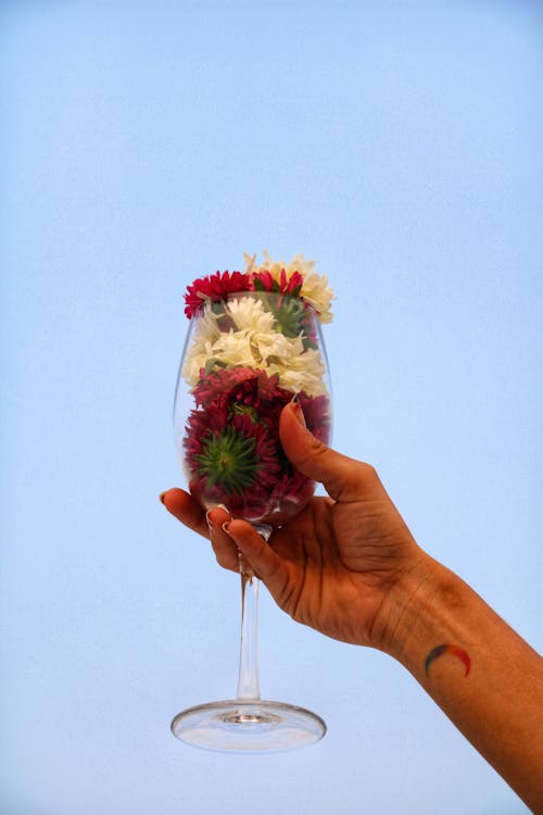 Person Holding Wine Glass With Flowers 