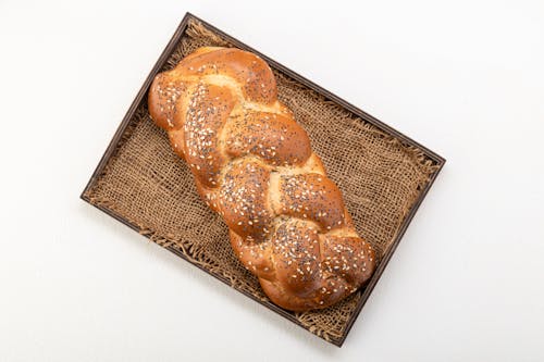 A Brown Bread on a Woven Mat on the Tray