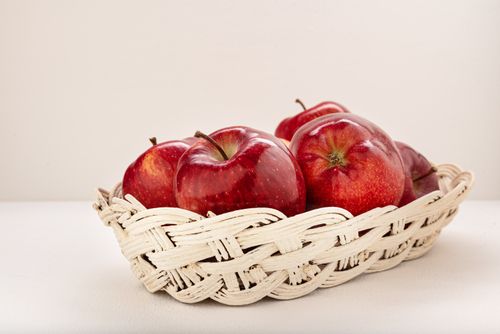 Free Close-up of ripe red apples in a decorative woven basket, signifying freshness. Stock Photo