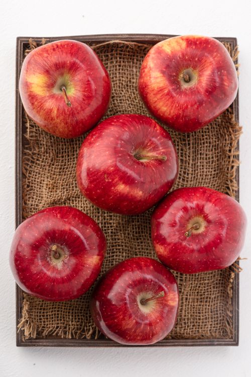 Free Top view of red apples on burlap, showcasing freshness and vibrant color. Stock Photo