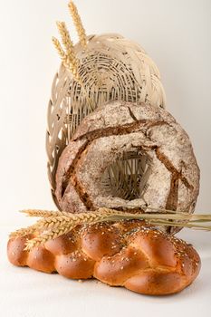 Close-up view of artisan breads with wheat in a basket for a rustic food presentation.
