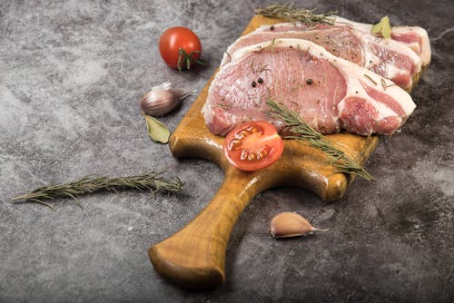 Free Uncooked Meat Slices on a Wooden Chopping Board Stock Photo