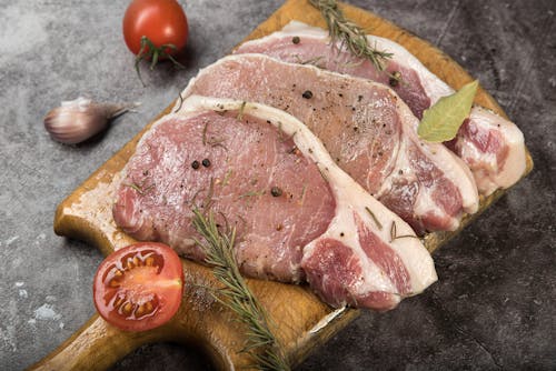 Free Porkchops on Wooden Chopping Board Stock Photo
