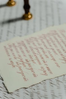 A close-up view of artistic calligraphy on textured paper, showcasing intricate handwriting.