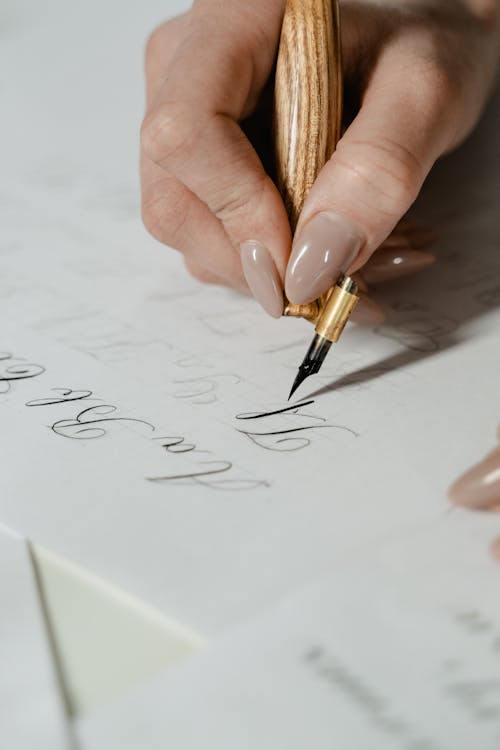 Free Close-Up Shot of a Person Writing on a Paper  Stock Photo