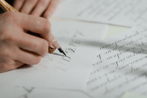 Close-Up Shot of a Person Writing on a Paper 